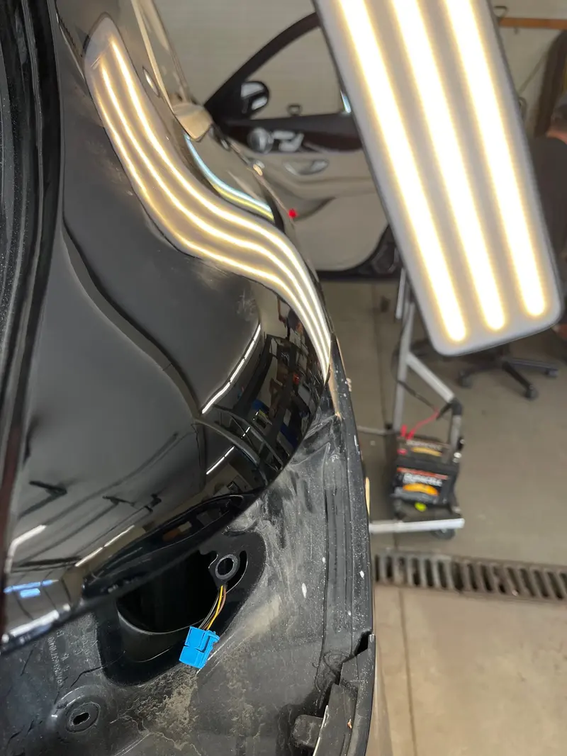 After: Fender dent restored to smooth factory finish via paintless dent repair