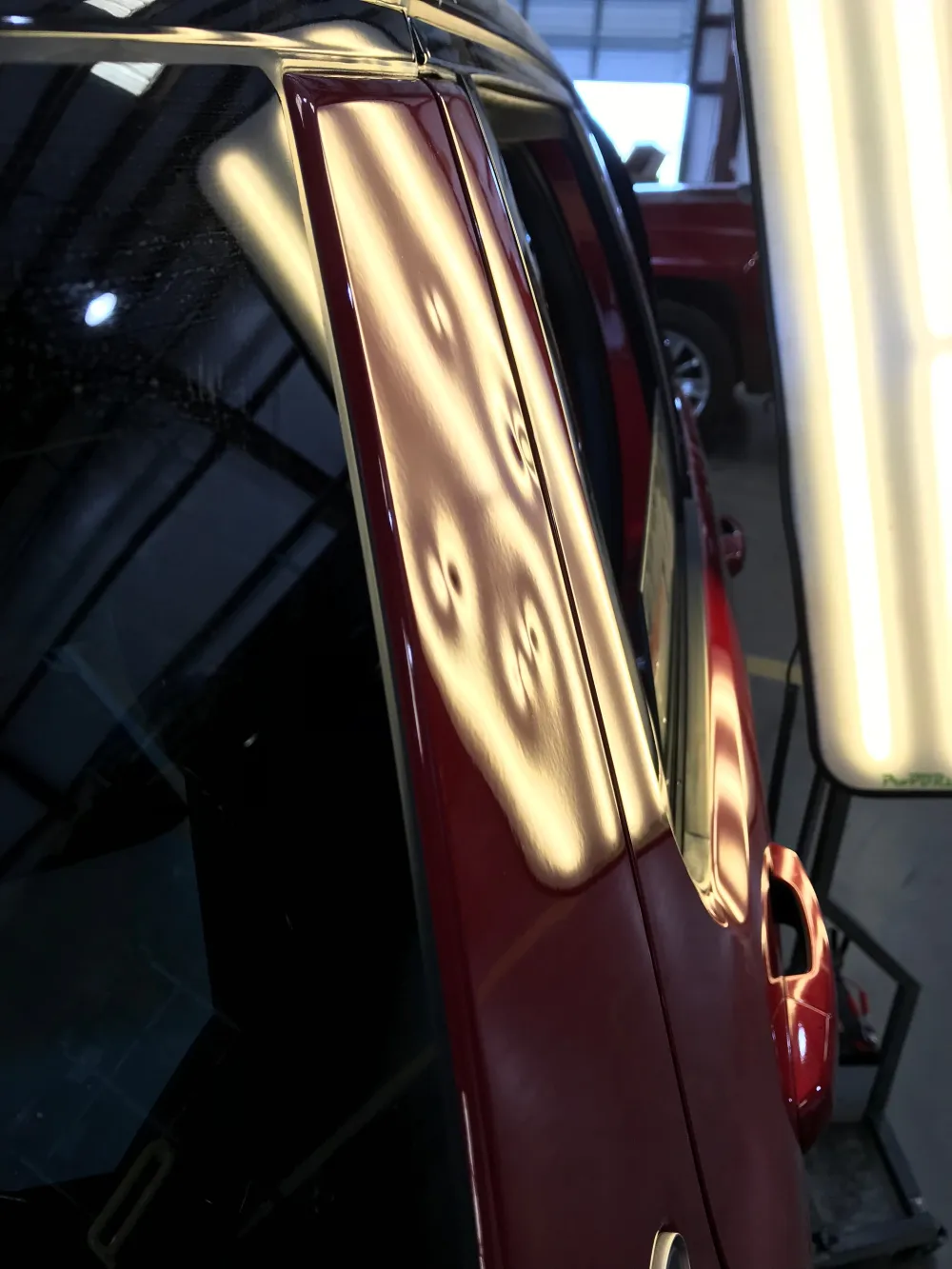 Hail damage across a vehicle hood and roof before PDR restoration