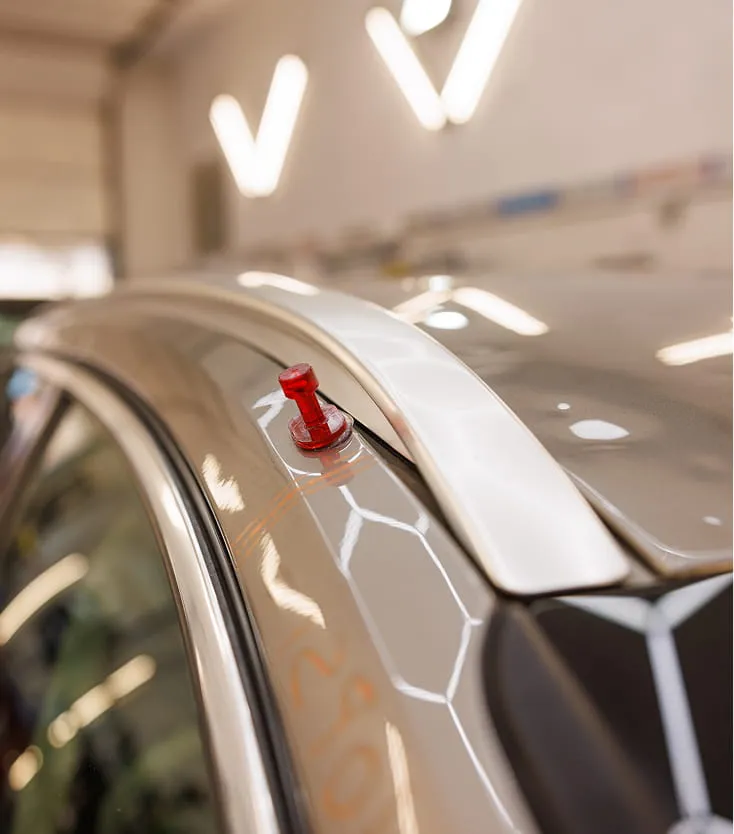 Technician inspecting hail damage under specialized PDR lighting